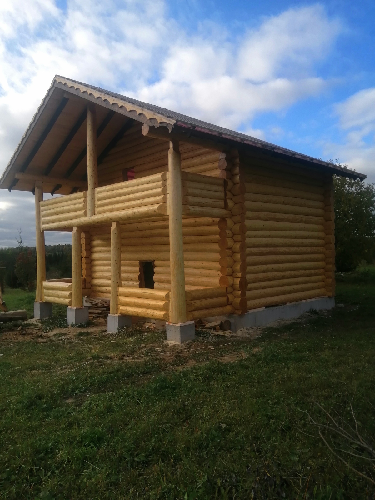 Баня с терассой и балконом из бревна ручной рубки