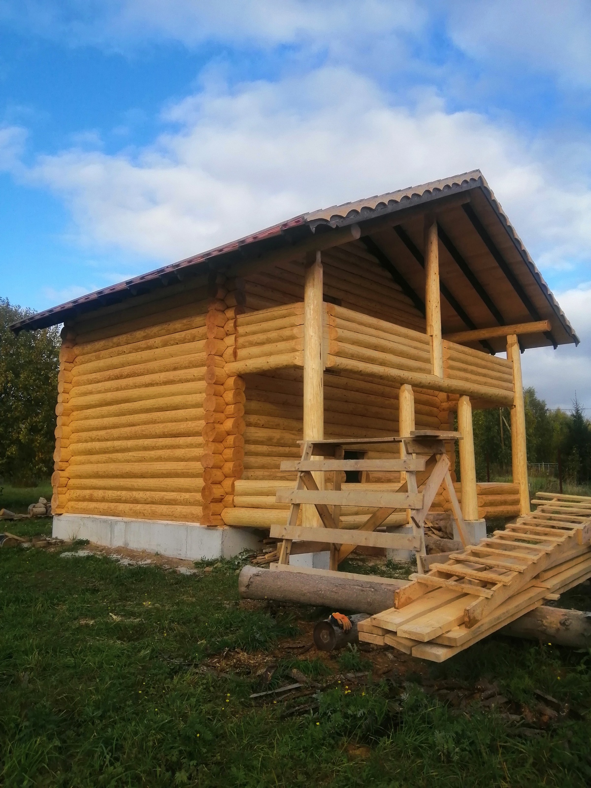 Баня с терассой и балконом из бревна ручной рубки