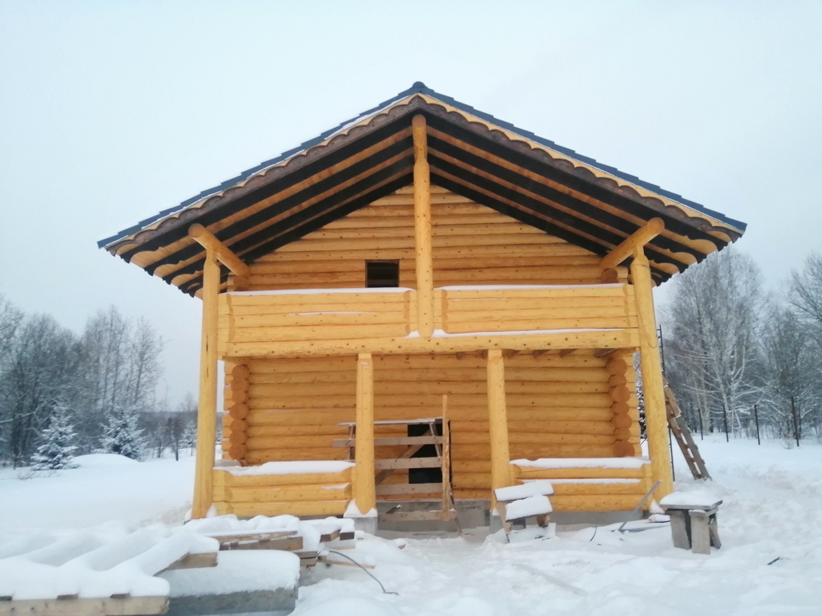 Баня с терассой и балконом из бревна ручной рубки